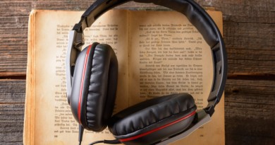 Headphones on the old book. Concept of listening to audiobooks.